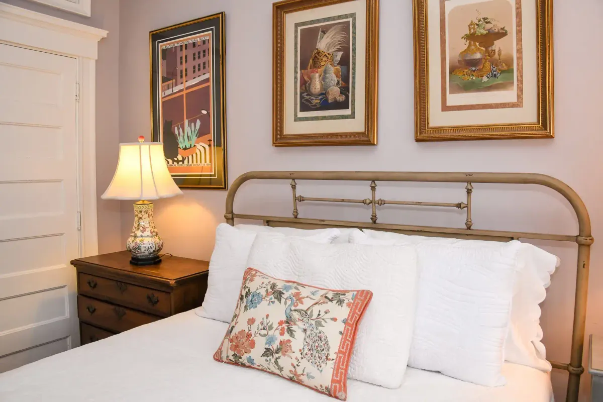 The Gallery Room at 48 Vauxhall, featuring art-lined walls and a luxurious queen bed